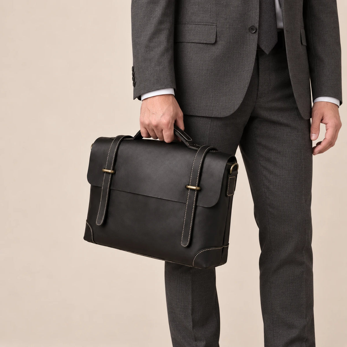 Sacoche en cuir noir à lanière portée à la main