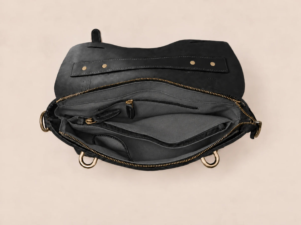 Intérieur de la sacoche en cuir noir à lanière, poche zippée et compartiment ordinateur