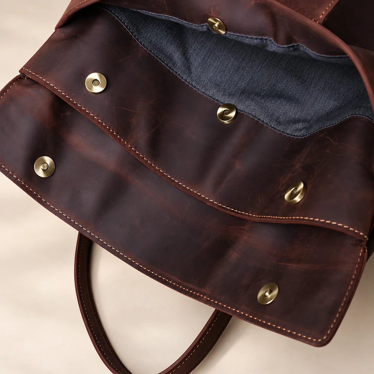 Macro de la fermeture à boutons-pression de la deuxième poche de la pochette en cuir marron foncé à rabat